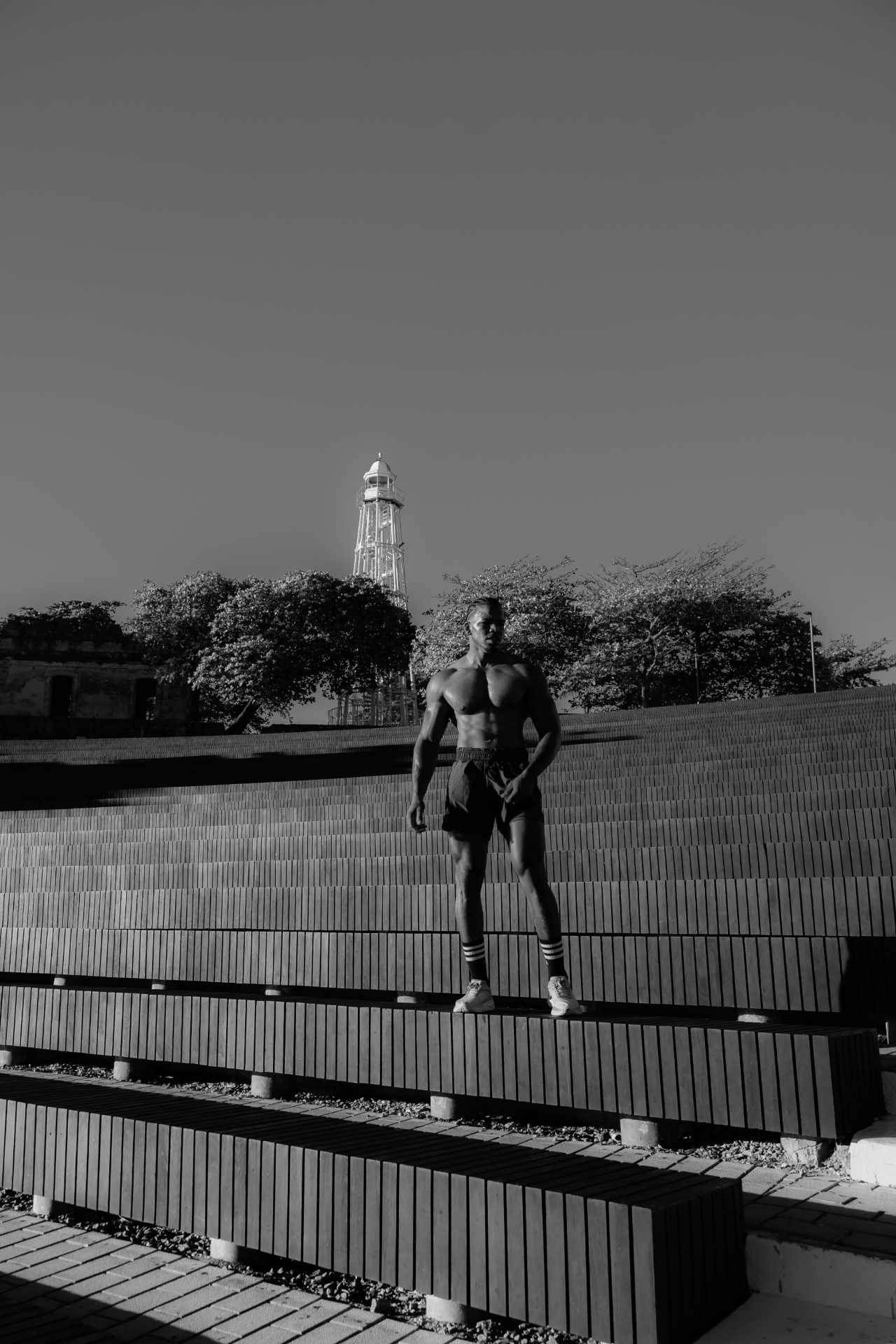 Foto en blanco y negro de un miembro en el anfiteatro con el faro de Puerto Plata detrás